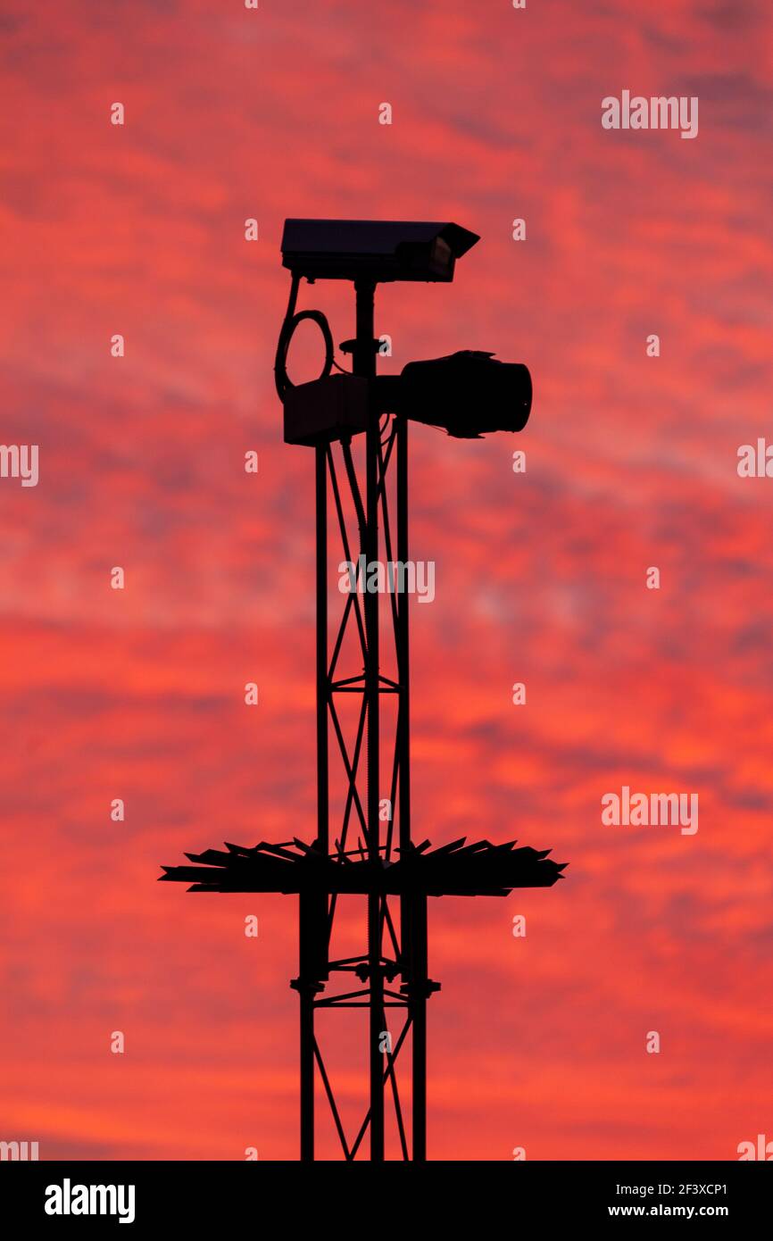 Security camera in silhouette against a pink sky Stock Photo