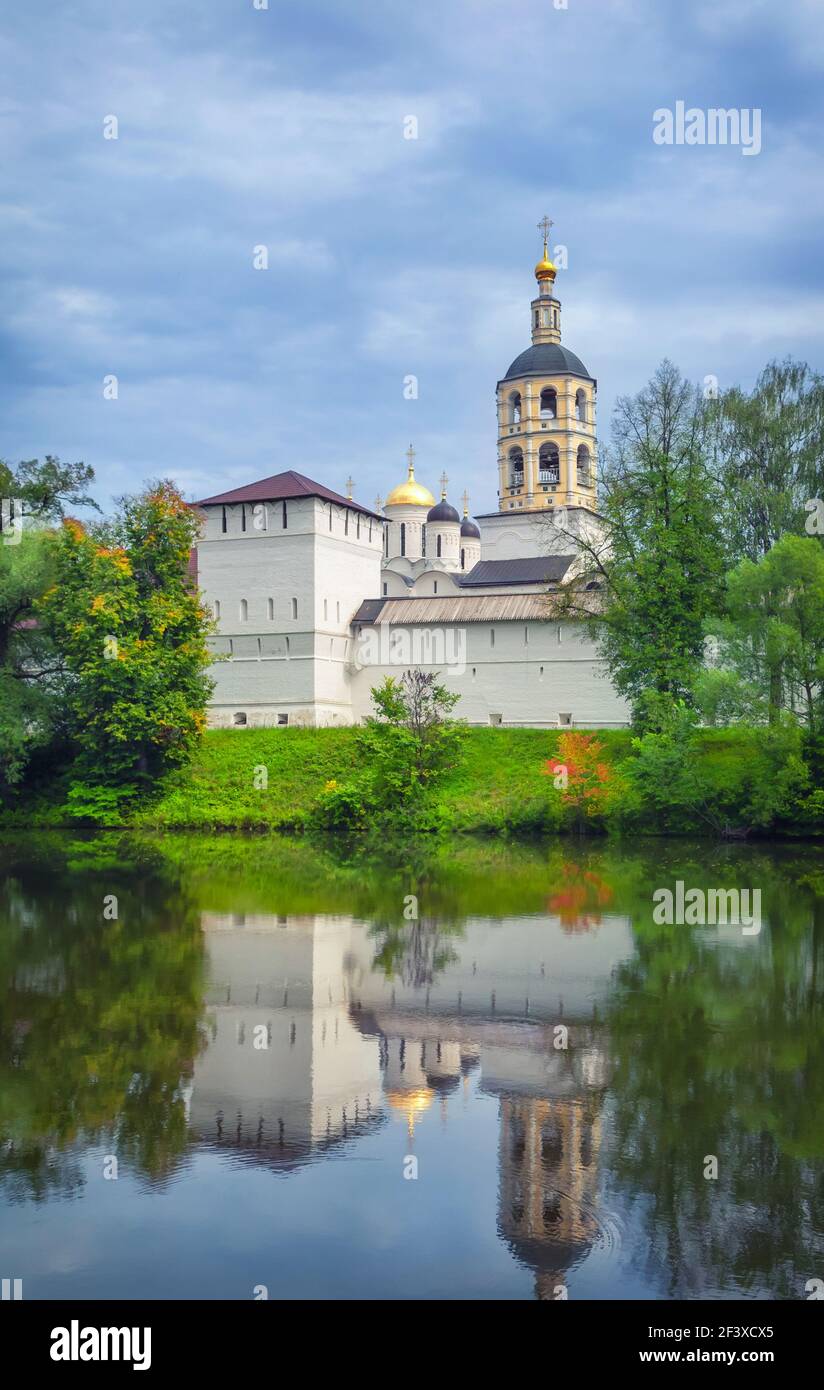 View of St. Paphnutius of Borovsk Monastery reflecting in water, Kaluga oblast, Russia Stock Photo