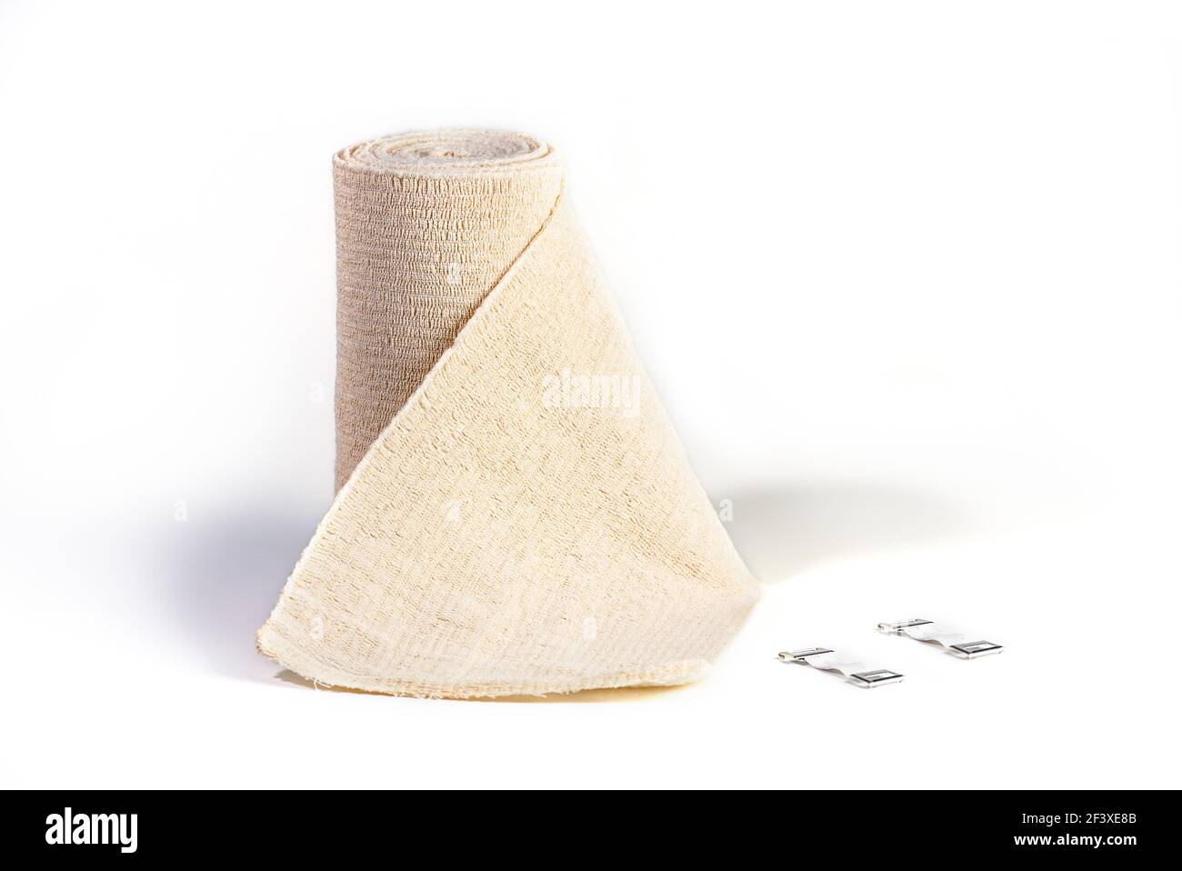 Woven elastic medical bandage rolled into roll and fixation clips. Compression Bandage on a white background Stock Photo