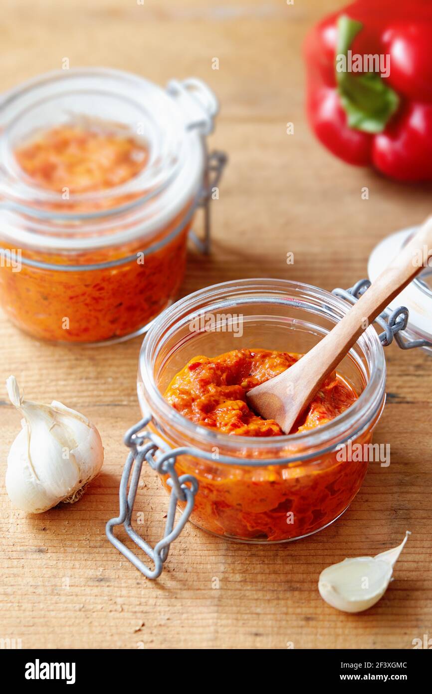 Roasted red pepper relish (Ajvar) in a jar with ingredients Stock Photo