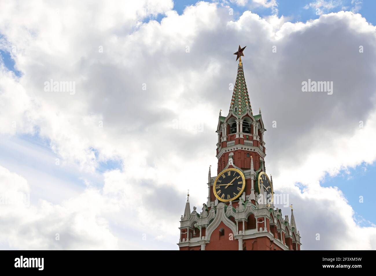 Chimes of Spasskaya tower, symbol of Russia on Red Square. Moscow Kremlin tower on blue sky and white clouds background Stock Photo