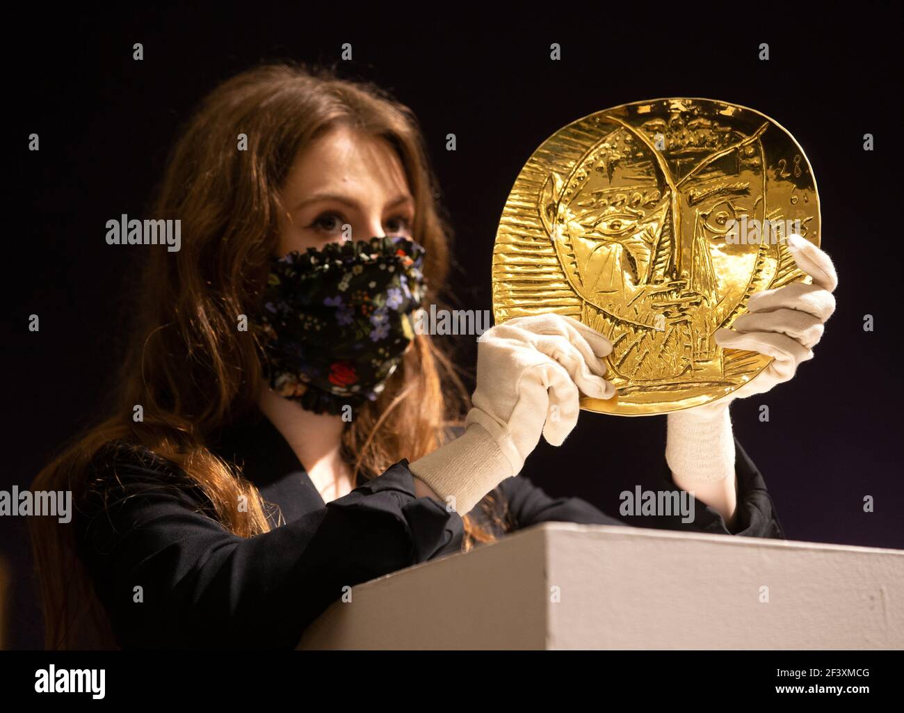 London, UK. 18th Mar, 2021. 'Visage de Faune', a 22 carat Gold plate by Pablo Picasso, estimated £250,000-350,000. The auction of artworks by Pablo Picasso will take place in London on March 23rd. Credit: Mark Thomas/Alamy Live News Stock Photo