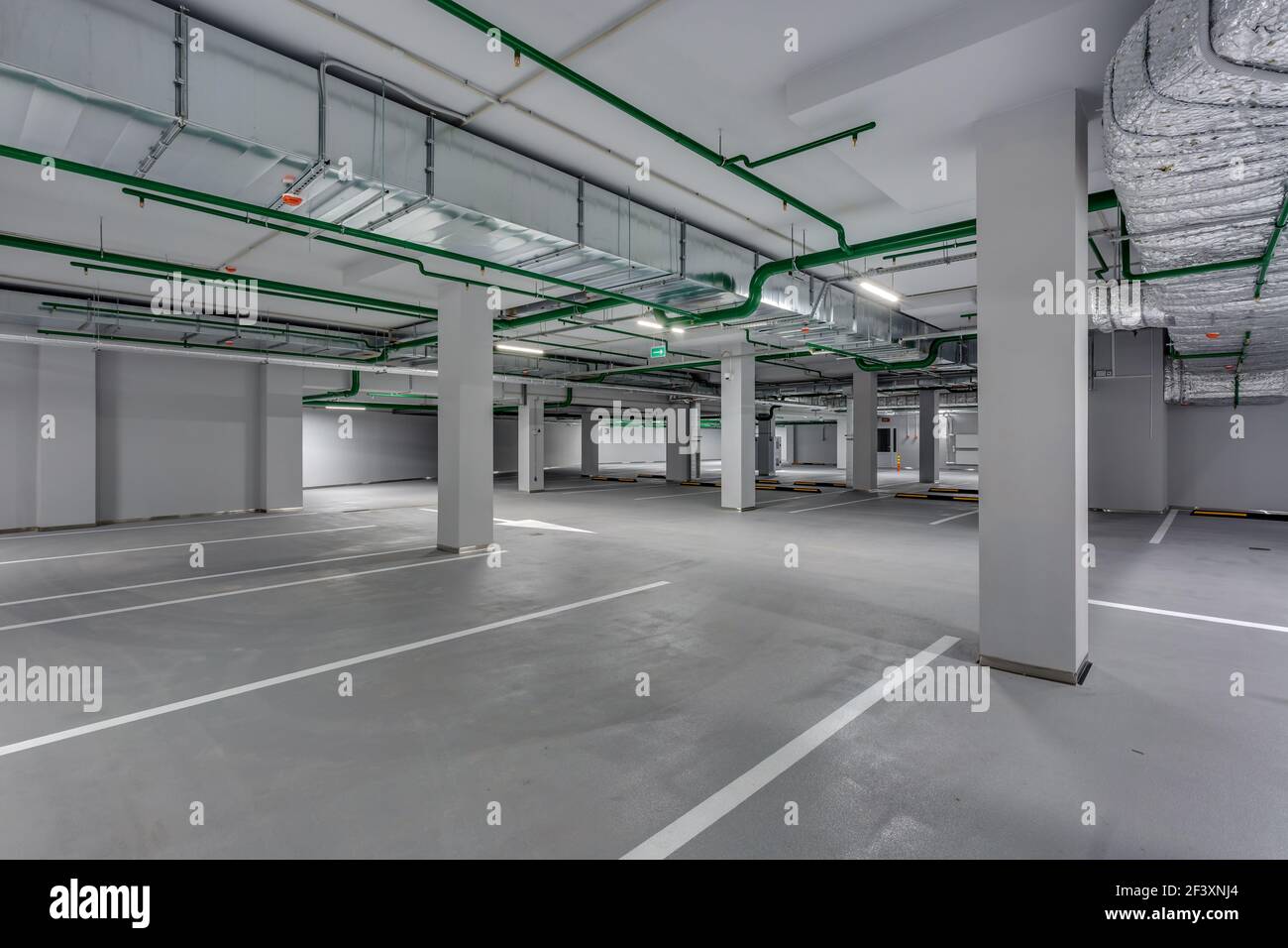 empty underground garage parking with columns and road markings Stock