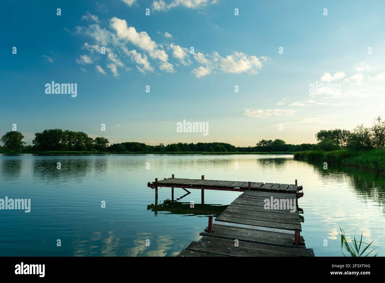 A wooden fishing pier and a calm blue lake, Stankow, Poland Stock Photo