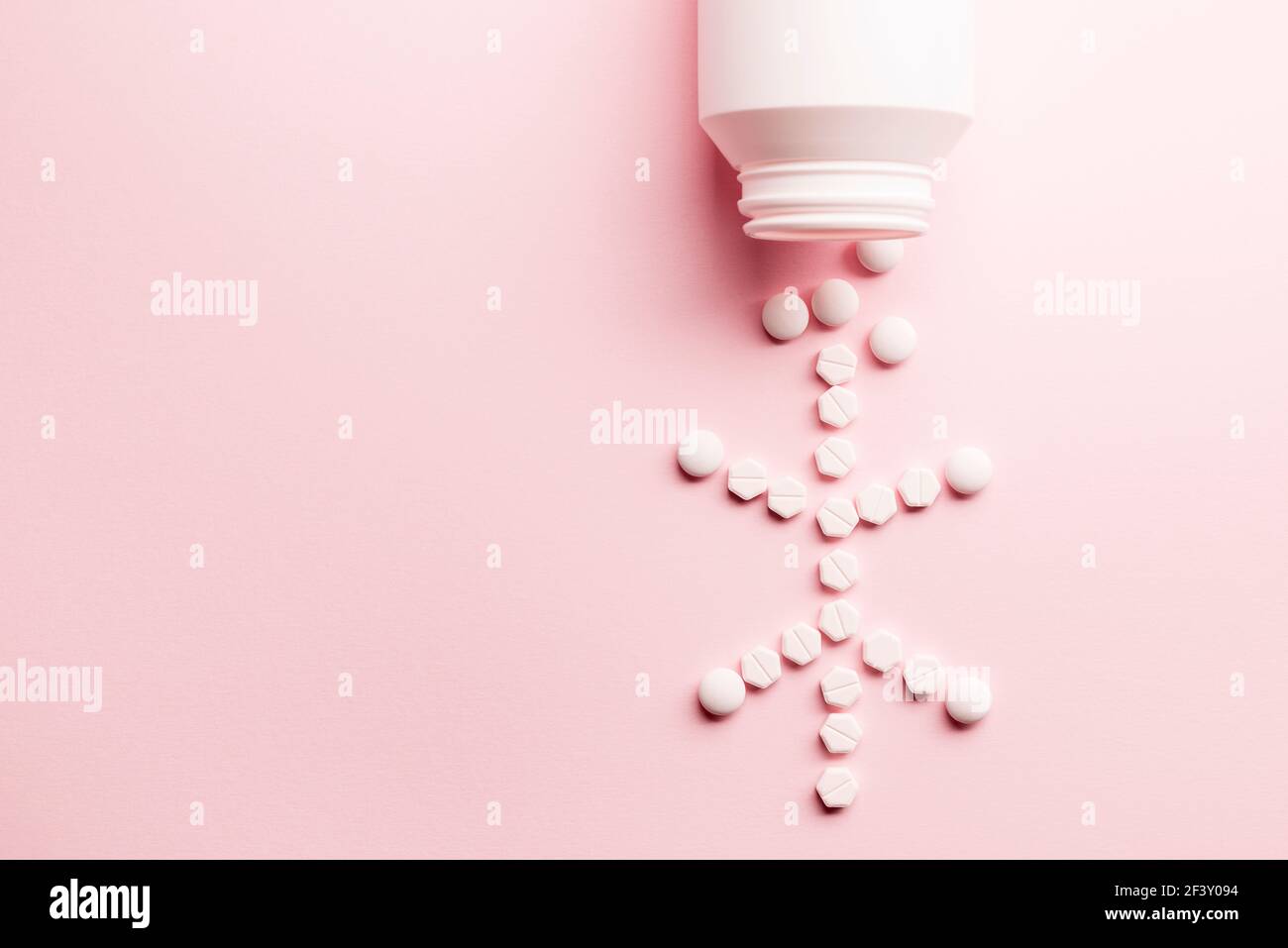 Medicine pills cell shape with bottle on pink background Stock Photo