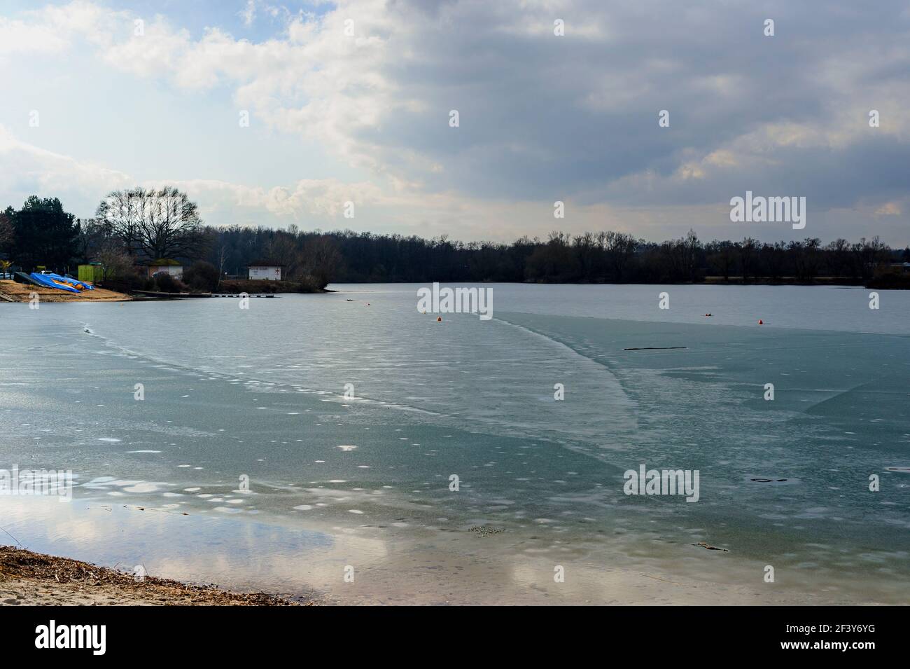 Frozen lake in Alsace, France. A thin film of ice covers the surface of the water. Stock Photo