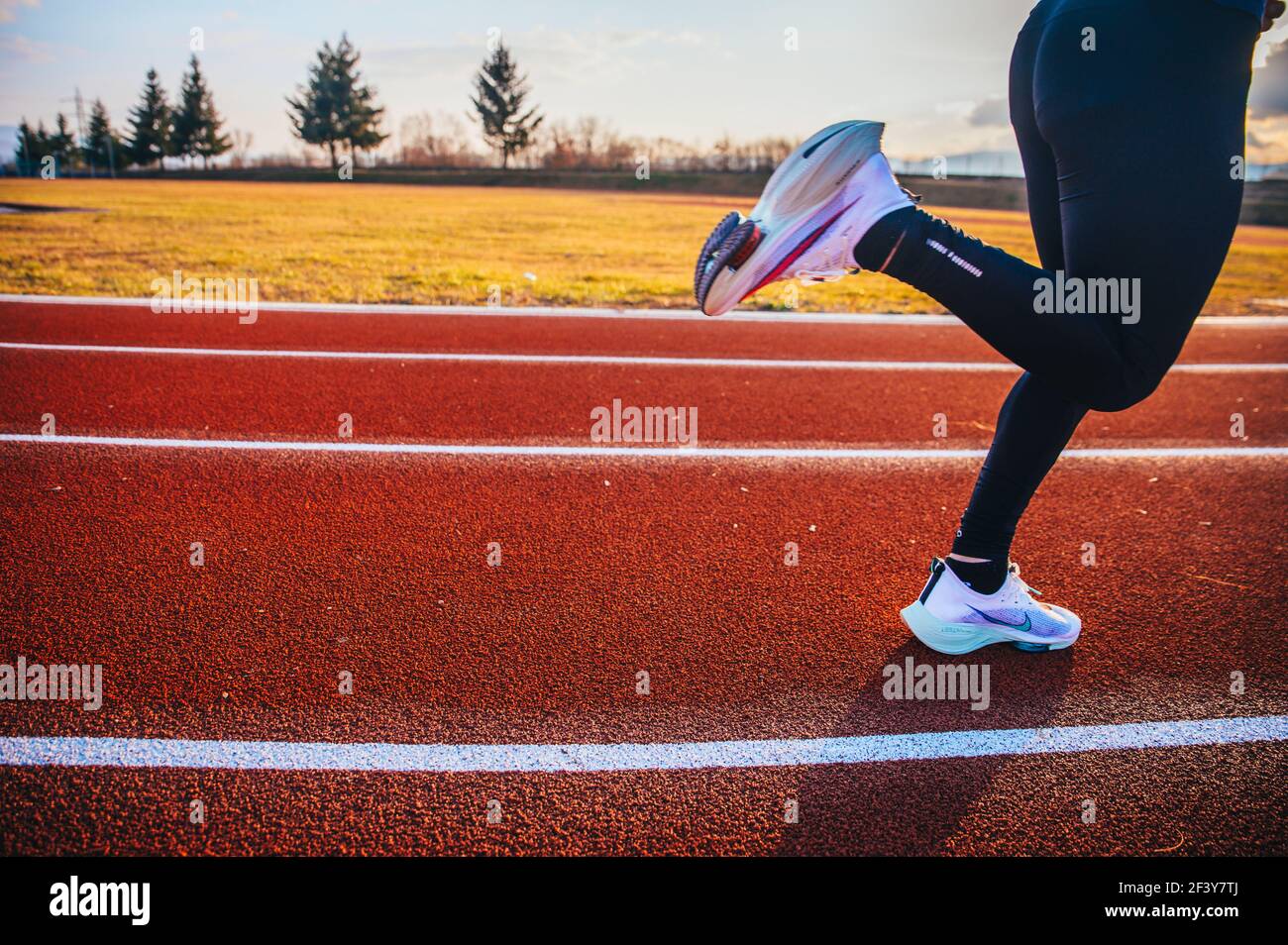 TOKYO, JAPAN, MARCH 18. 2021: Nike running shoes ALPHAFLY NEXT%. Controversial athletics shoe on legs of professional athlete running on the road. Off Stock Photo