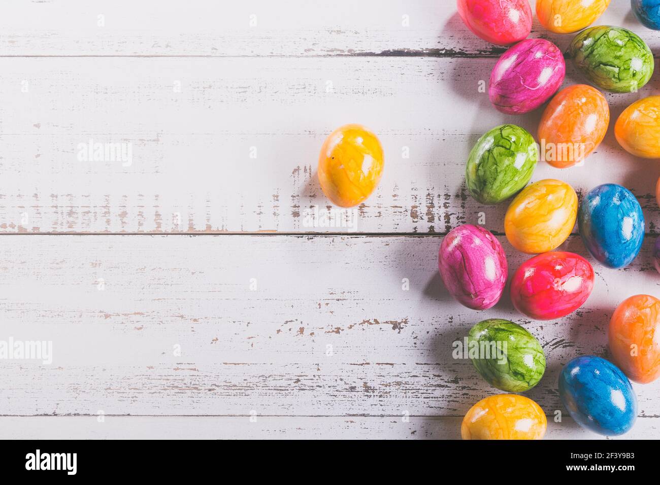 Easter wooden background with coloured eggs. Stock Photo