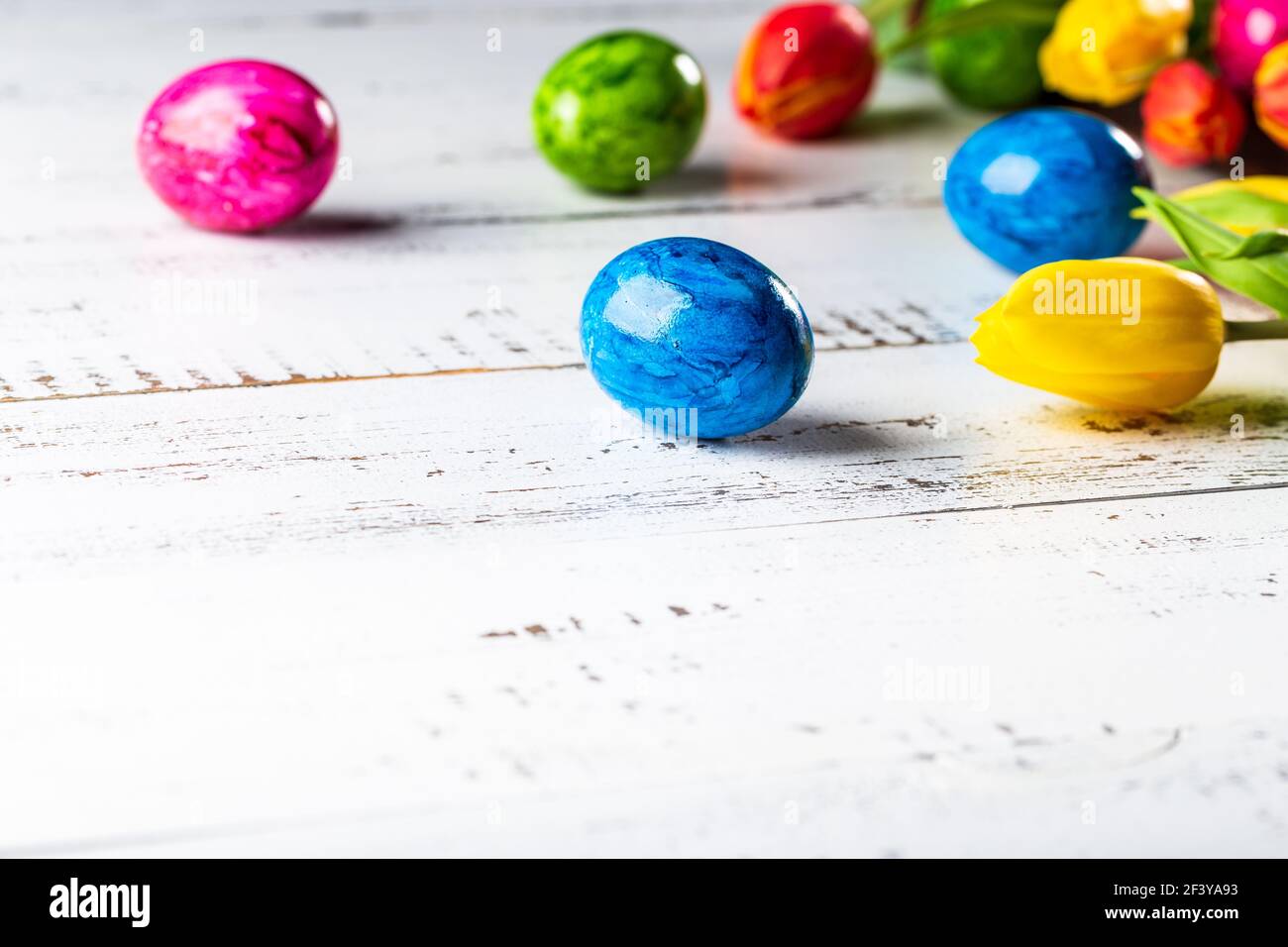 Easter wooden background with coloured eggs. Stock Photo