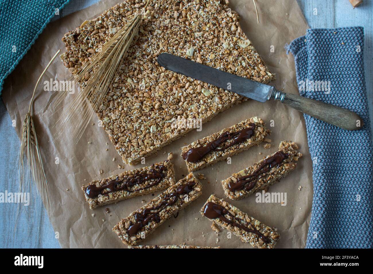 homemade no bake granola bar with nuts, seeds, puffed cereal, honey and maple syrup. From above view with rustic knife Stock Photo