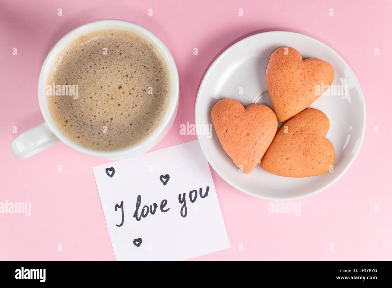 note with the words I love you with cookies shaped heart and cup ...