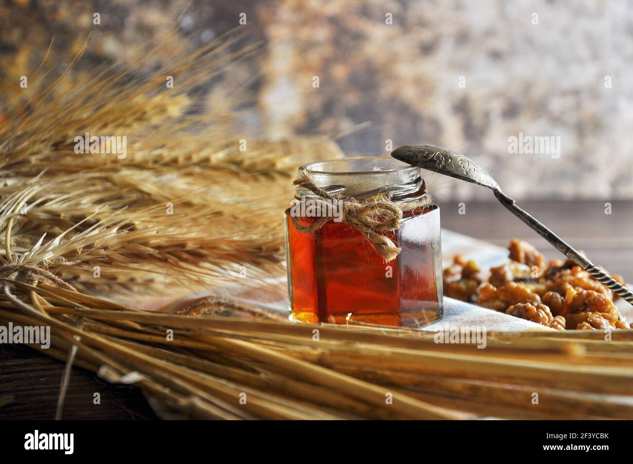 A honey jar with a spoon for honey and different nuts on white background  Stock Photo - Alamy
