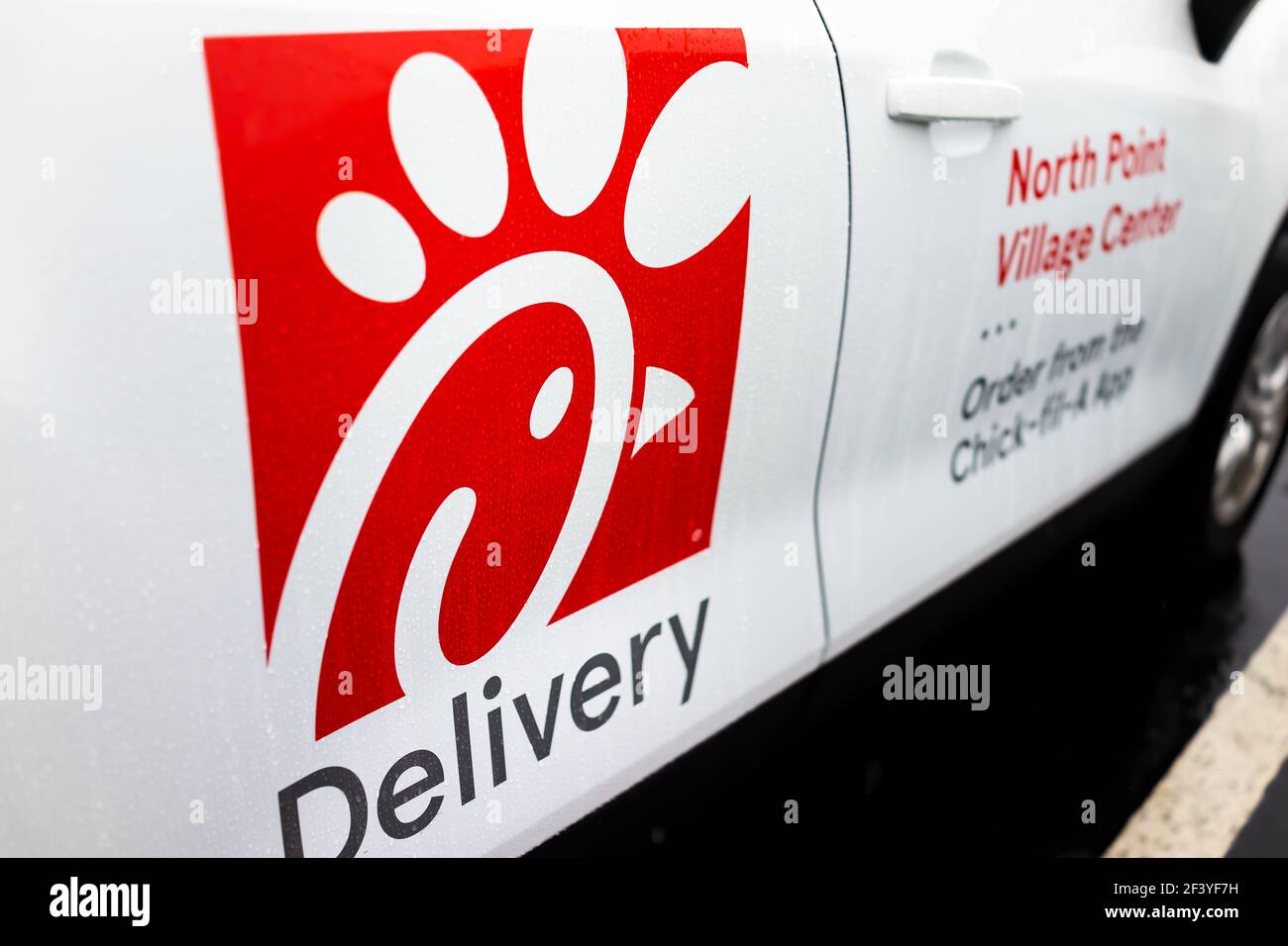 Herndon, USA - December 14, 2020: Chick-fil-a branded delivery car delivering online app orders of chicken sandwich food with logo on door at parking Stock Photo