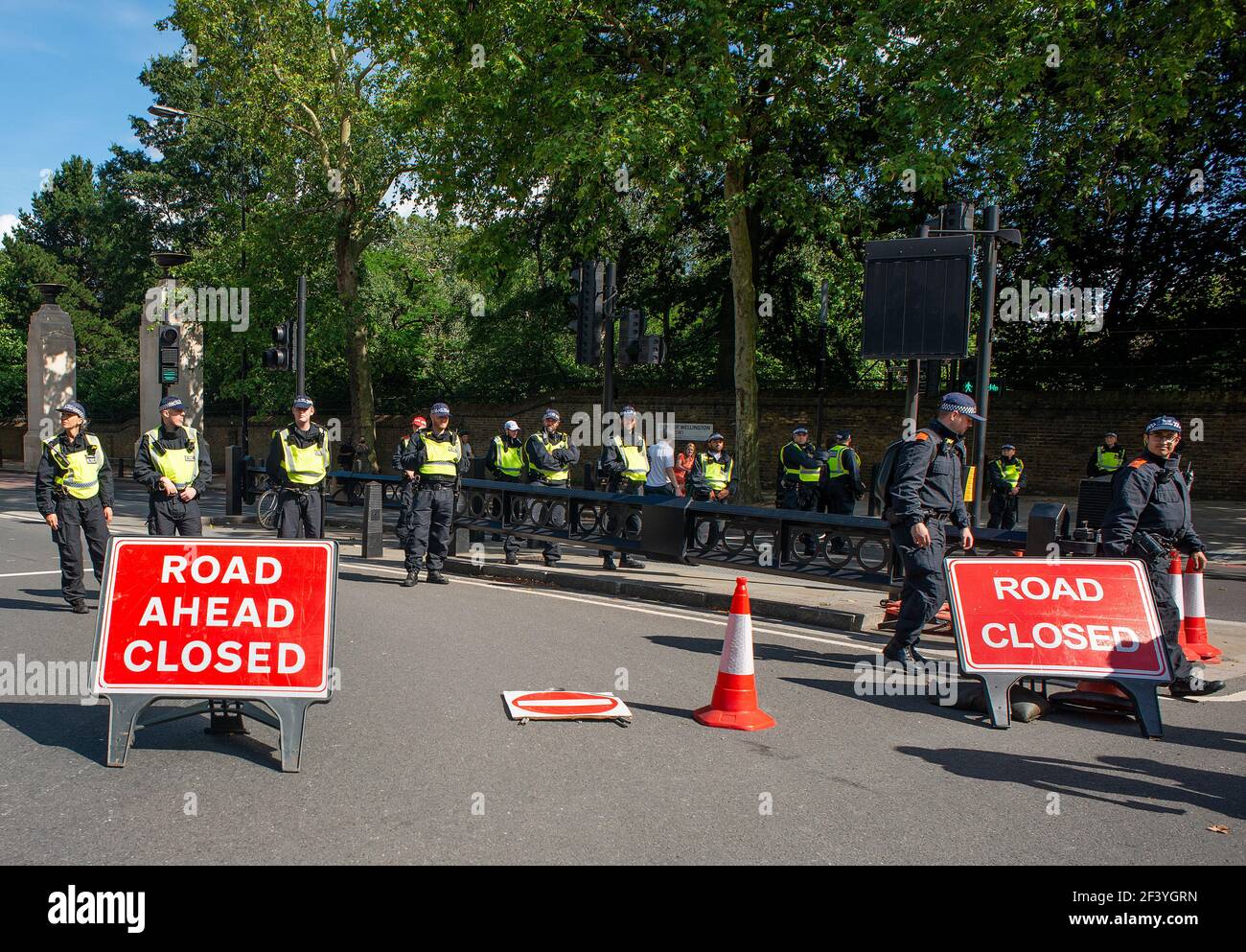 Metropolitan Police officers with road signs, form a line to create a road block to divert a protest demonstration towards another route. Stock Photo
