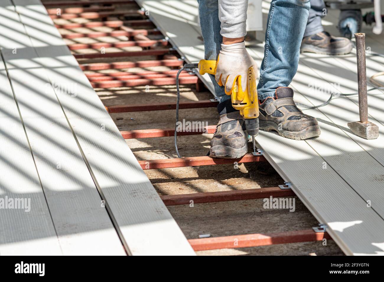 Man assembling composite deck using cordless screwdriver. Stock Photo