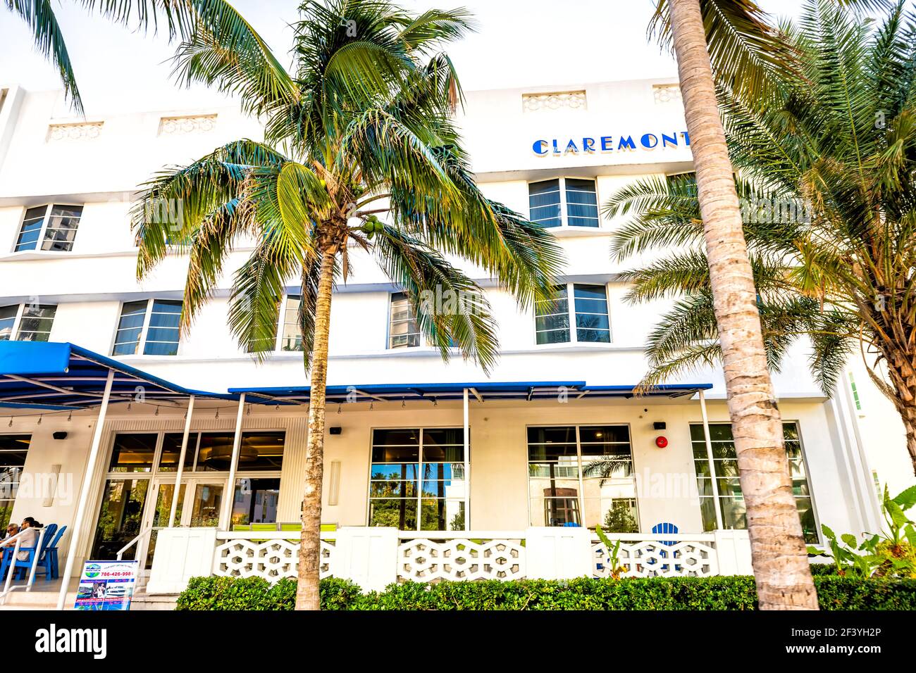 Miami Beach, USA - May 5, 2018: Florida Art Deco Claremont Hotel in South Beach with people eating at sidewalk outdoor cafe restaurant at Ocean Drive Stock Photo