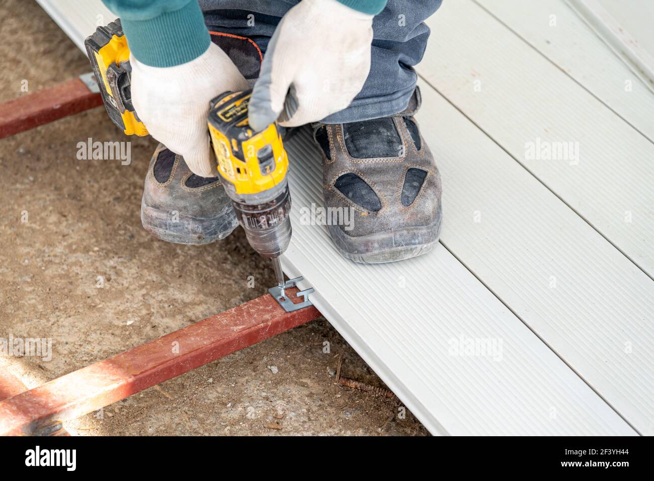 Man assembling composite deck using cordless screwdriver. Stock Photo