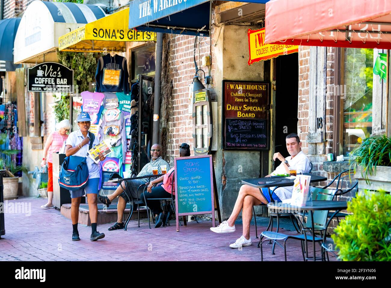 Savannah, USA - May 11, 2018: Old town River street district in Georgia southern city with brick architecture, people eating at restaurant cafes, shop Stock Photo
