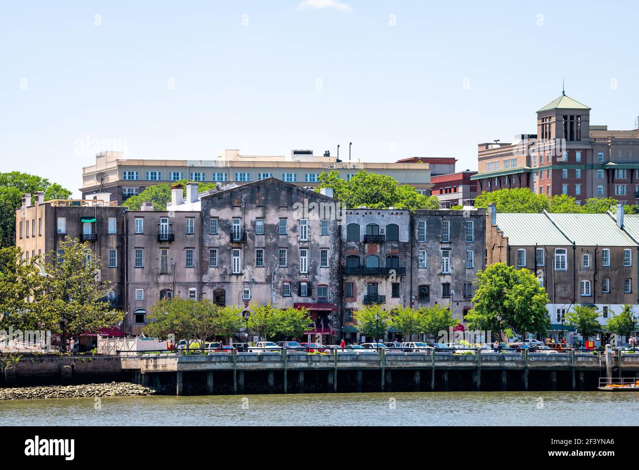 Savannah, USA - May 11, 2018: Cityscape skyline by River street old town waterfront with people walking in shopping district of restaurants, cafes and Stock Photo