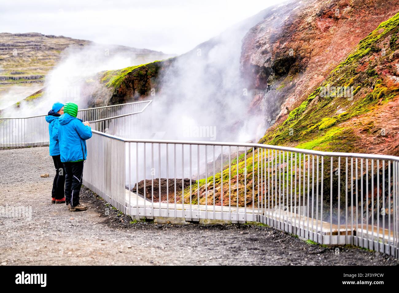 Deildartunguhver, Iceland - June 18, 2018: Hot springs and people looking at hot water outside in summer with vapor steam rising from cave Stock Photo