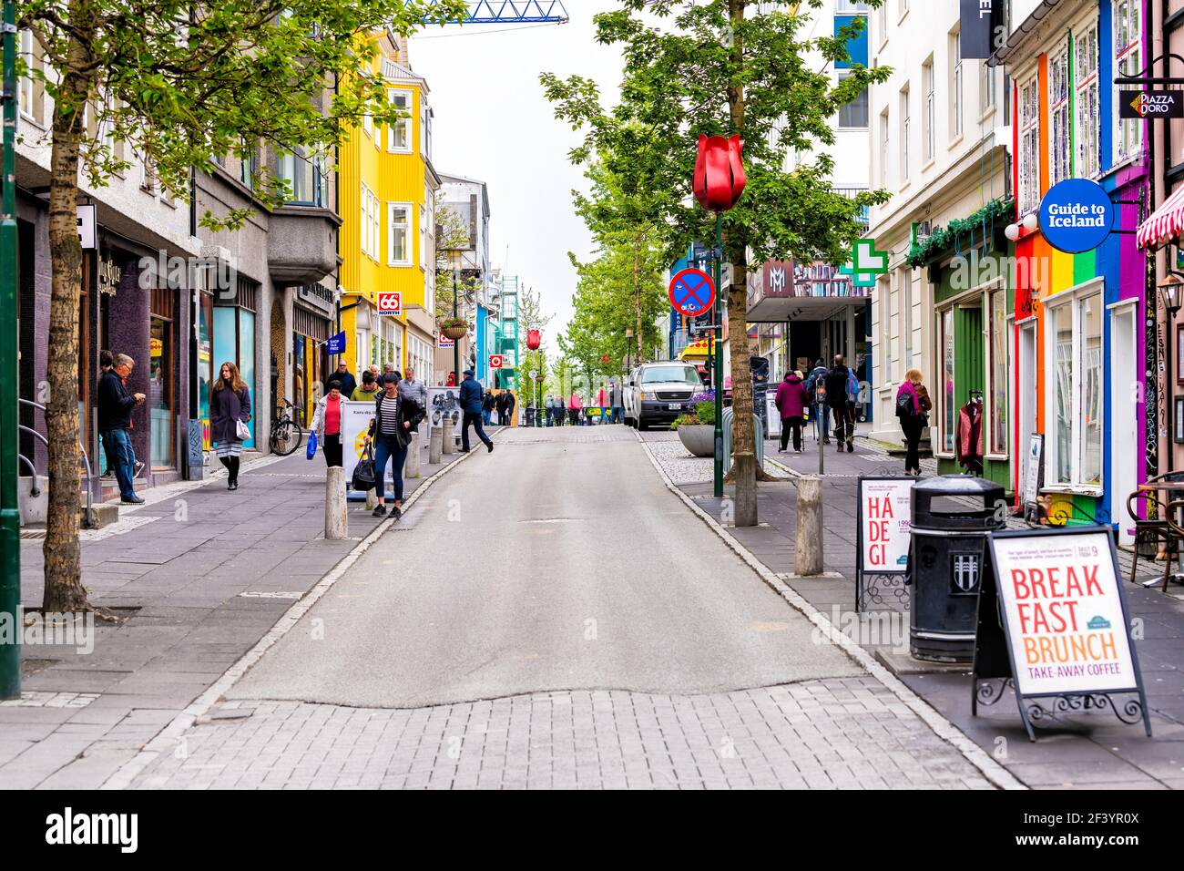 Reykjavik, Iceland - June 19, 2018: Laugavegur shopping street road sidewalk in downtown center and signs for stores shops and tourist guide Stock Photo