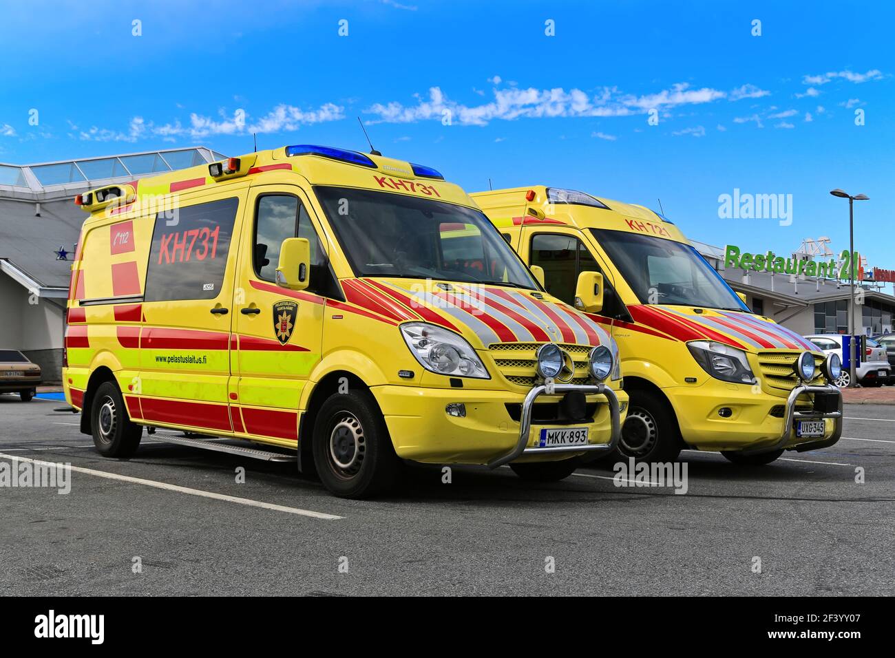 Two ambulance vehicles parked outside a service station. Finland. Stock Photo