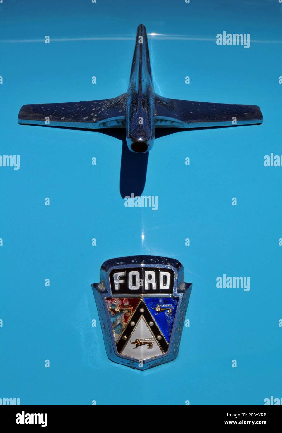 The emblem and hood ornament on a classic blue Ford Customline automobile. Stock Photo