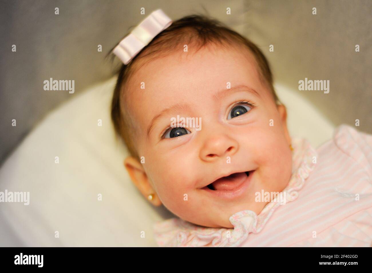 Baby girl two months old smiling indoors Stock Photo