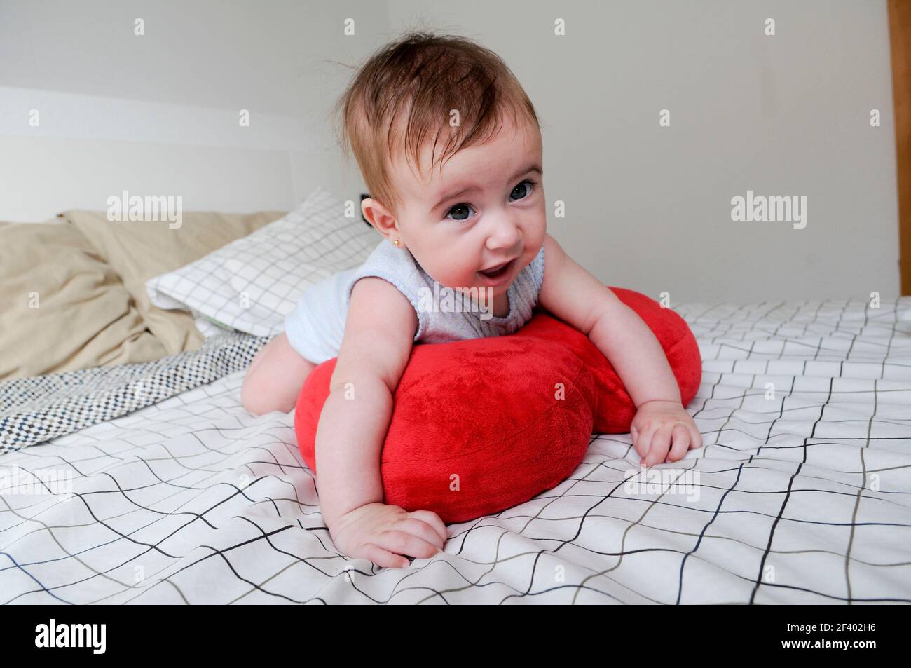 Happy baby girl, five months old, on the bed Stock Photo Alamy