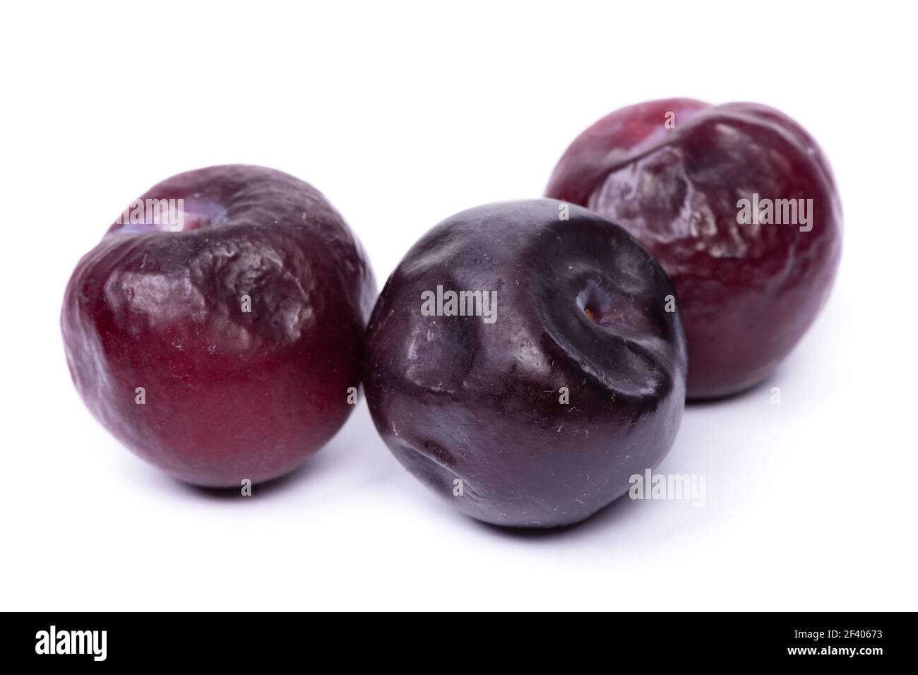 Group of overreipe plums isolated on white background Stock Photo