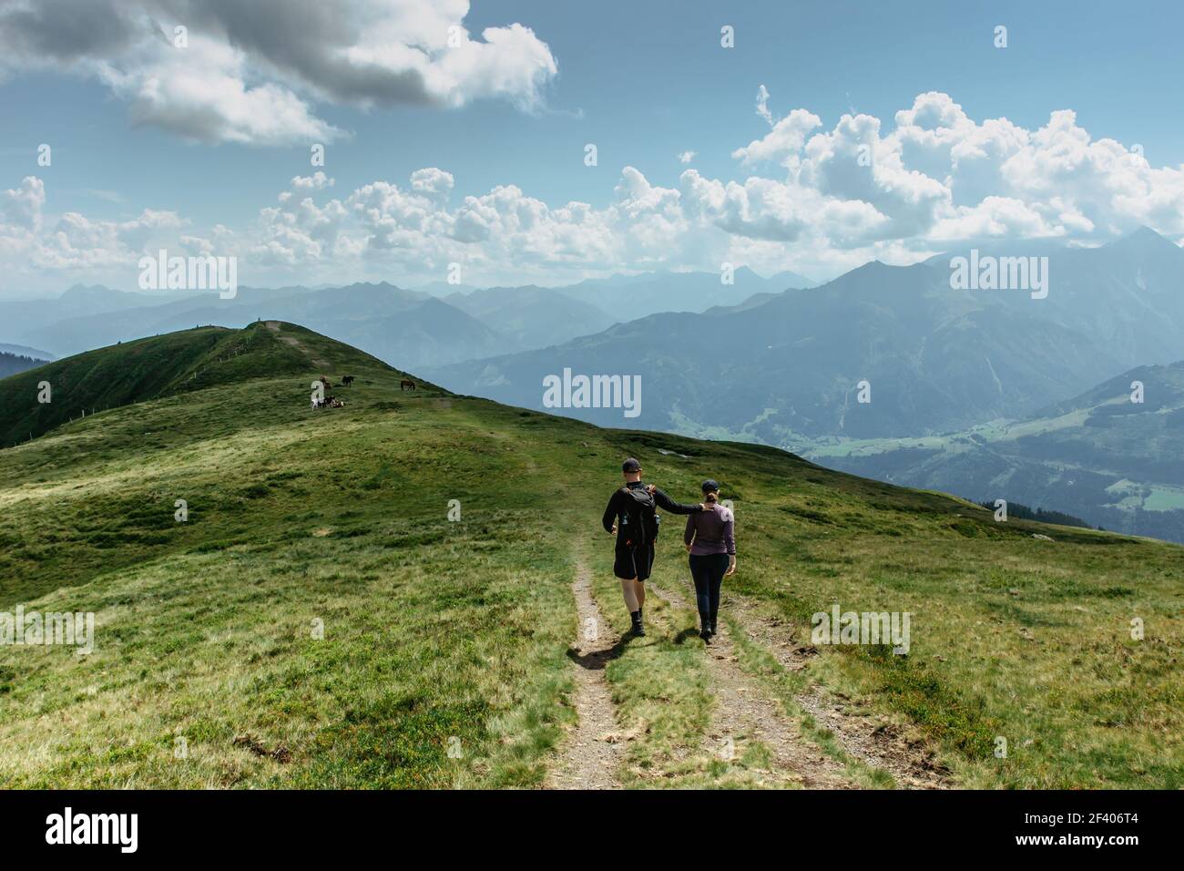 Man and woman backpackers trekking in Alps, Austria.Active healthy lifestyle.Couple in love walking together on peaks.Friends in mountains.Hiking Stock Photo