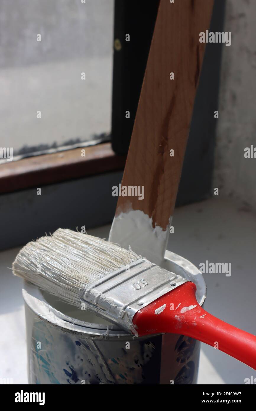 Workshop Photo of Used Paintbrush Lying on Top of Can. White Color Dirt Over Can. Stock Photo