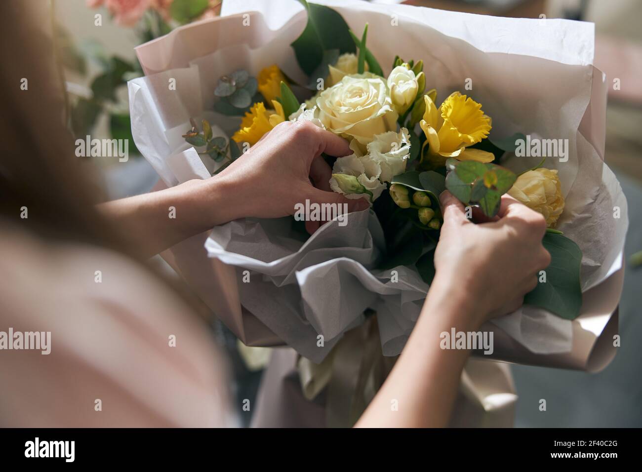 Nice and colorful bouqette of different flowers. Female florist hold it. She is in flower shop. Close up Stock Photo