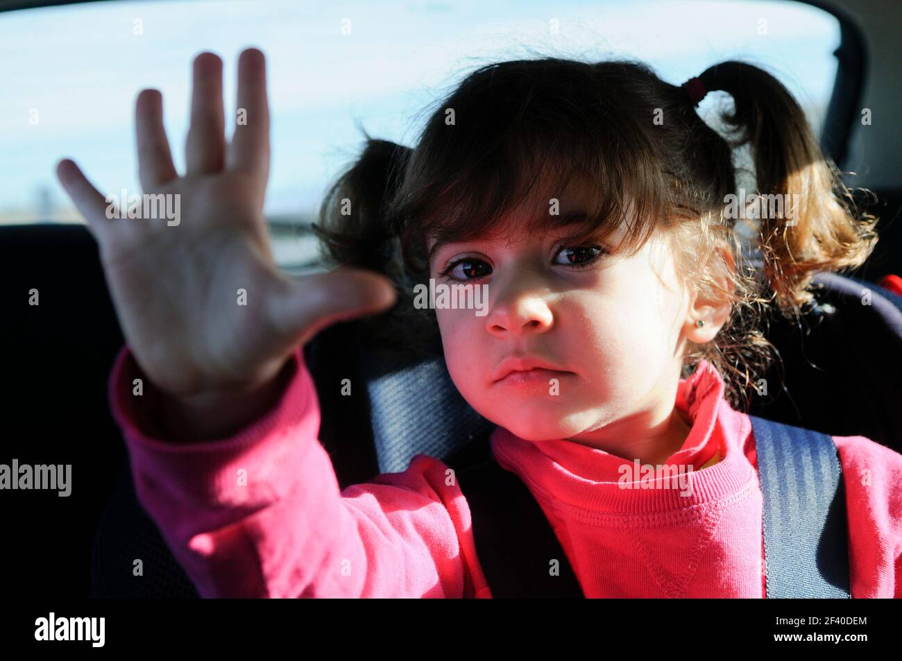 Adorable little girl traveling by car sitting in her safety seat Stock Photo