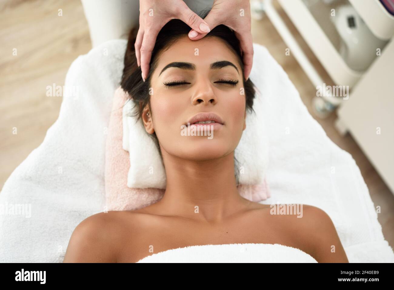 Arab woman receiving head massage in spa wellness center. Beauty and Aesthetic concepts Stock