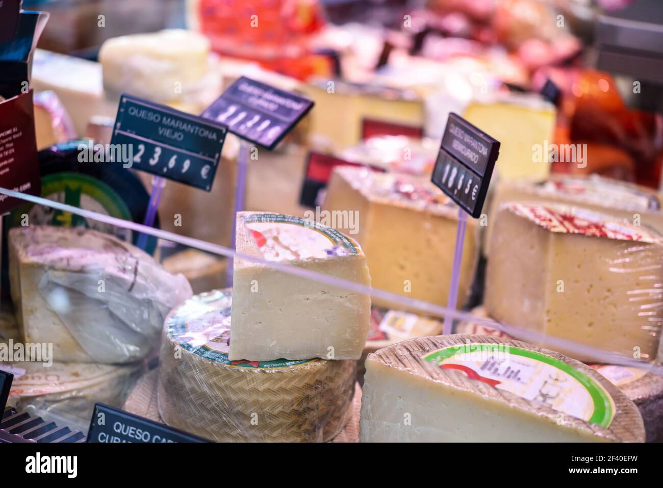 Refrigerated display case with cheeses in a butcher shop Stock Photo