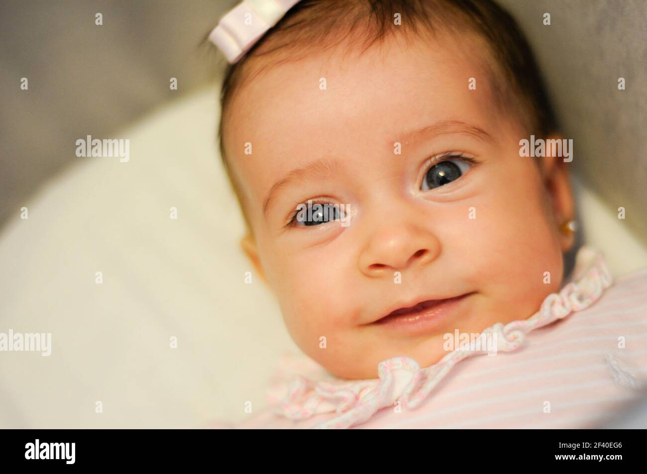 Baby girl two months old smiling indoors Stock Photo