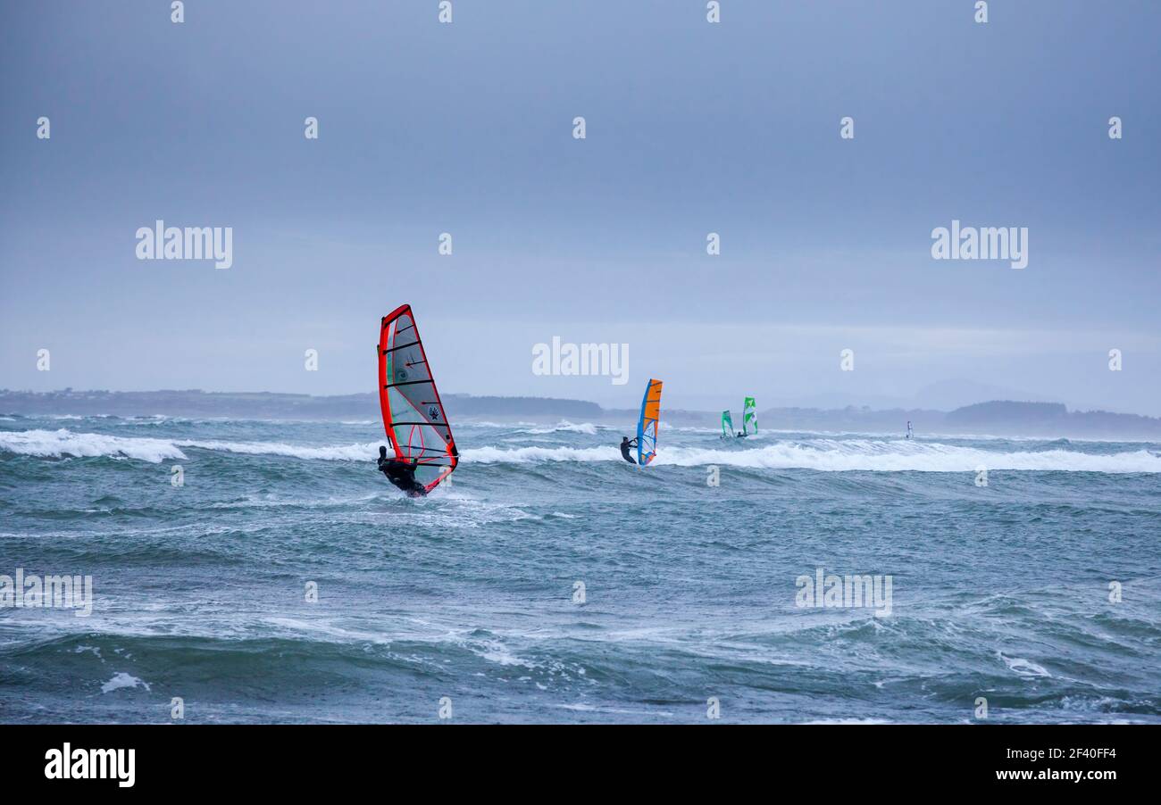 Windsurfers during a winter storm on Rhosneigr Beach, Anglesey, Wales Stock Photo