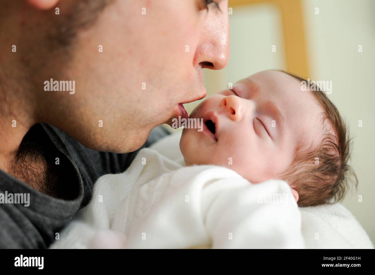Father kissing his newborn baby girl. Close-up portrait Stock Photo