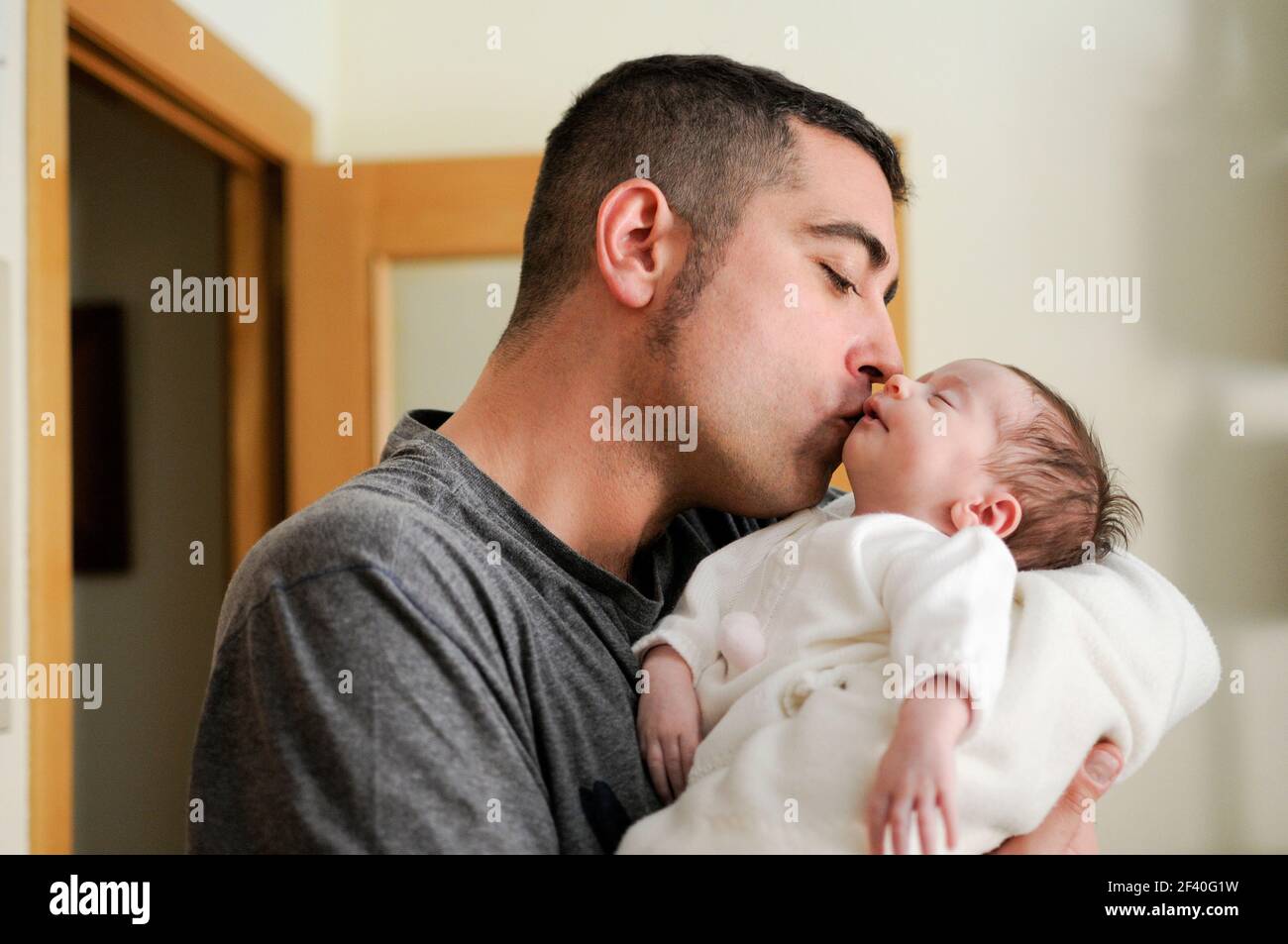 Father kissing his newborn baby girl. Close-up portrait Stock Photo
