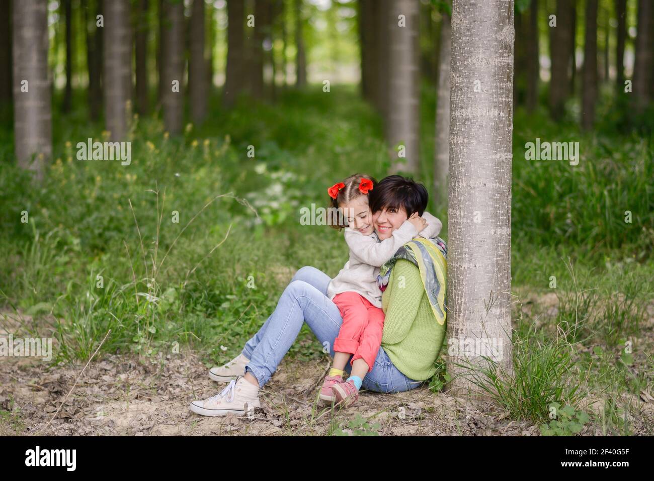 Happy mother with her little daughter in poppy field Stock Photo