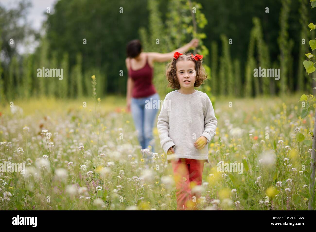 Happy mother with her little daughter in poppy field Stock Photo