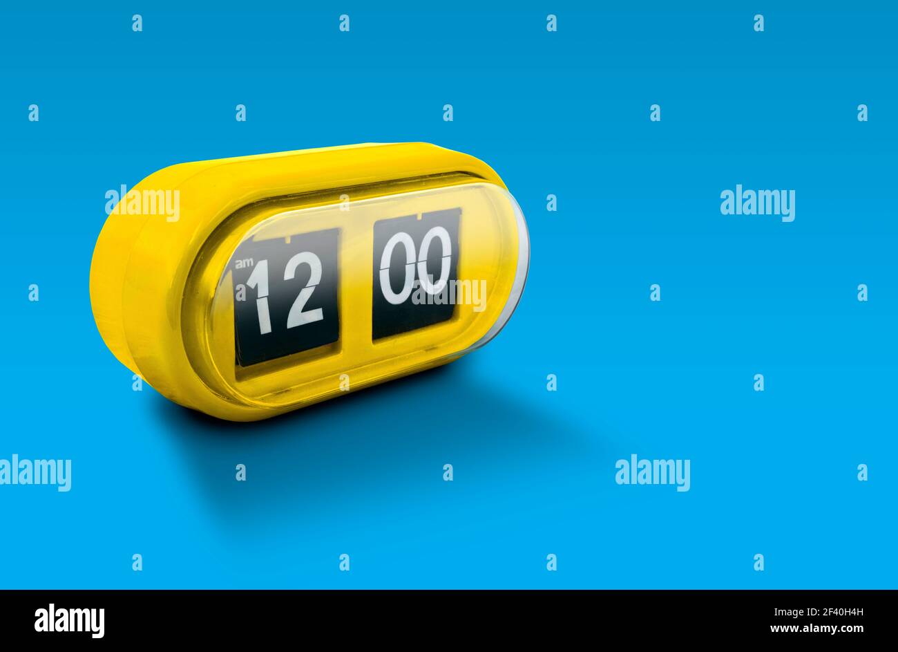 Yellow alarm clock isolated on blue background Stock Photo