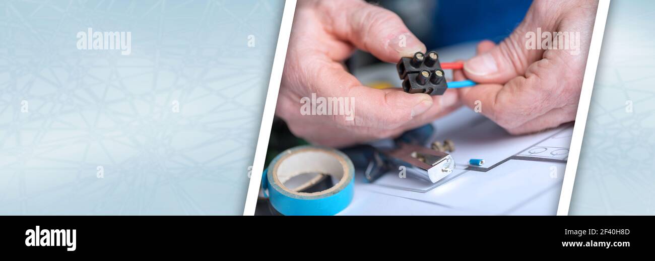 Electrician hands connecting wires in terminal block. panoramic banner Stock Photo