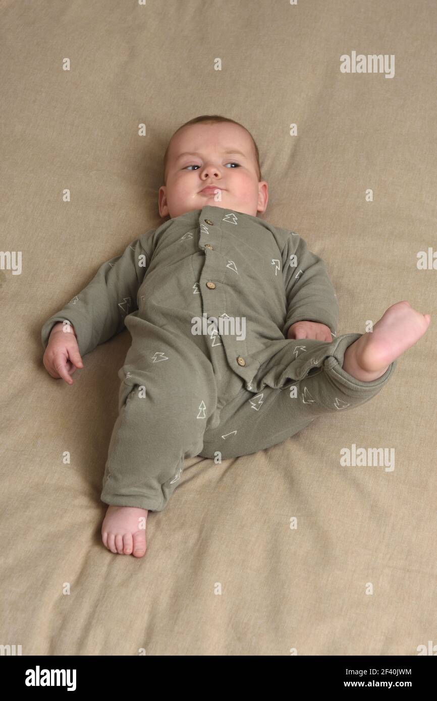 a baby that is lying down and raises his foot Stock Photo Alamy