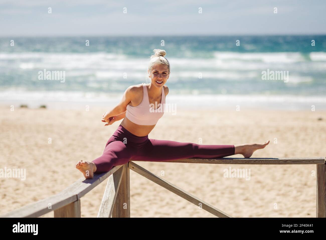 caucasian-woman-practicing-yoga-at-seashore-young-female-stretching