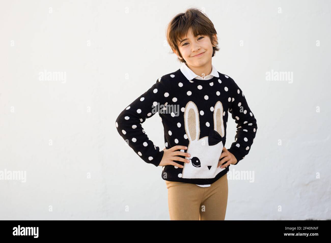 Nice seven years old girl with short hair smiling on camera on a white wall.. Seven years old girl with short hair smiling on a white wall Stock Photo