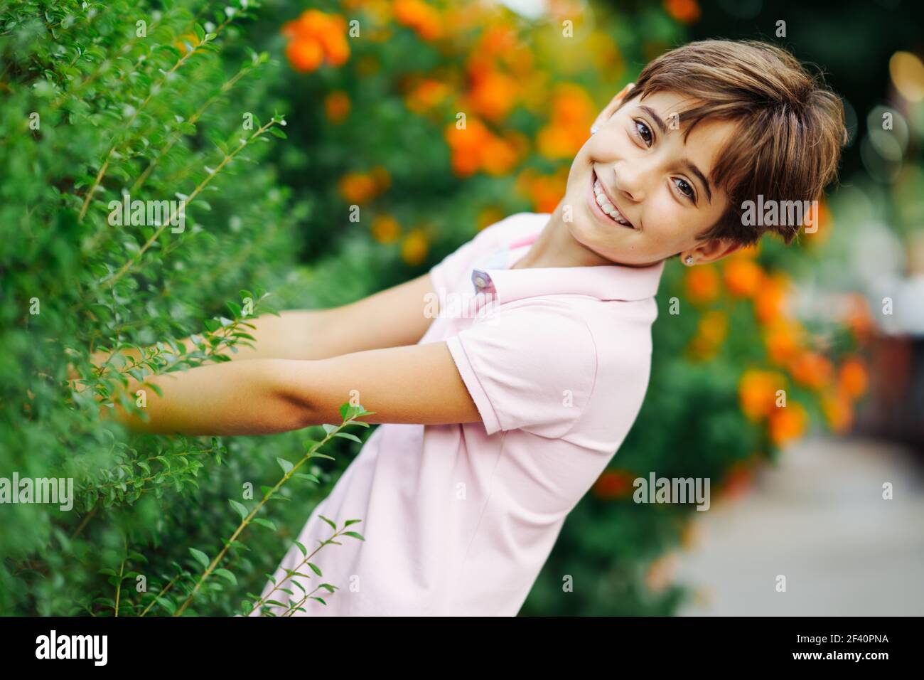 Little girl with very short hair, having fun in an urban park wearing