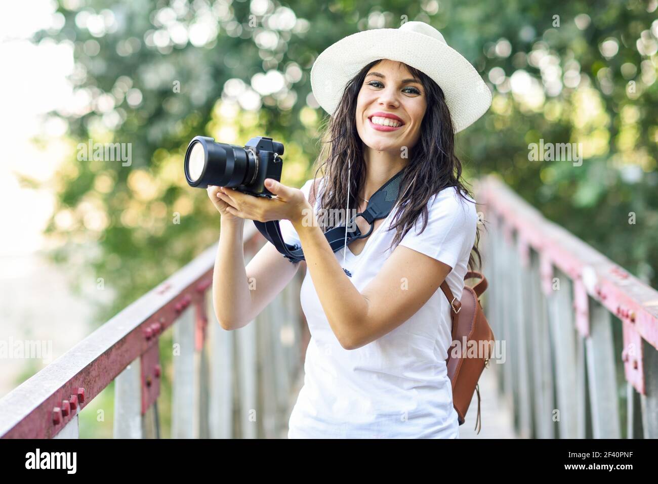 Beautiful hiker young woman taking photographs with a mirrorless camera