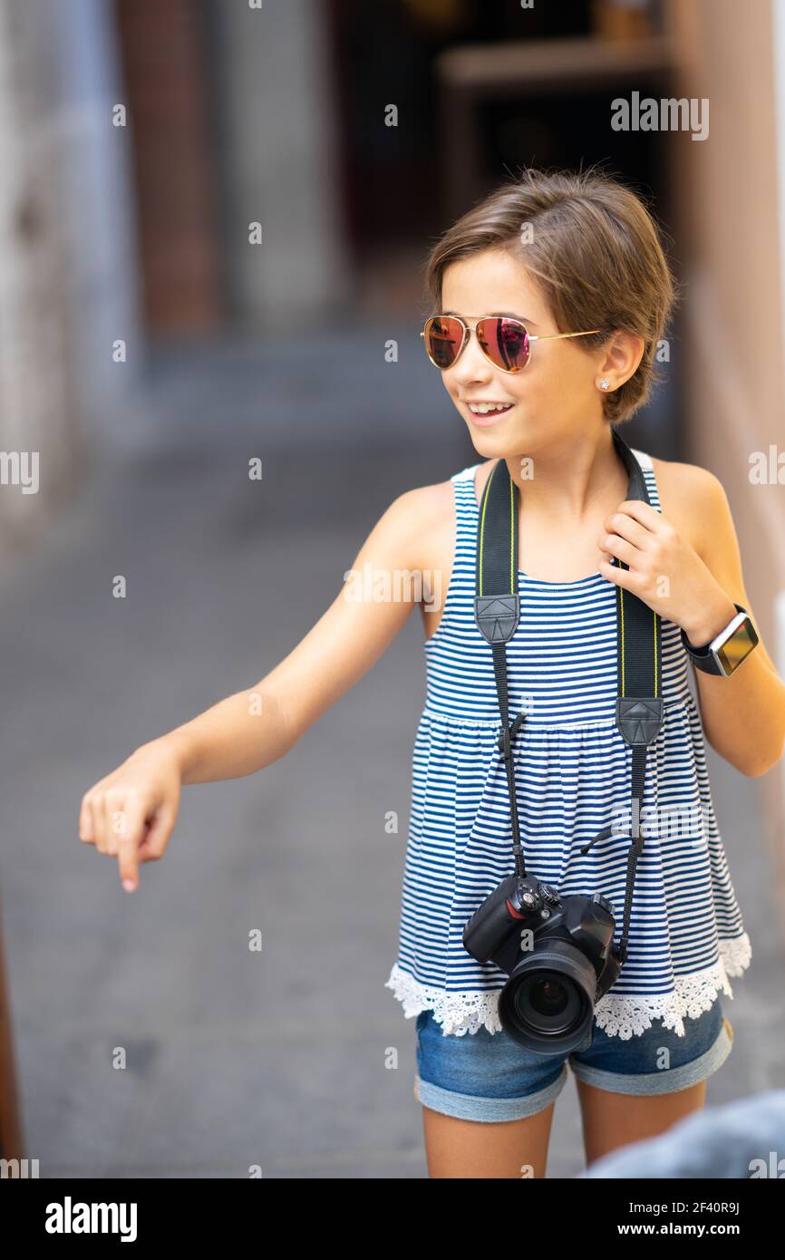 Little girl making photo with DSLR camera on city street. Small female traveling in urban background.. Little girl making photo with DSLR camera on city street Stock Photo